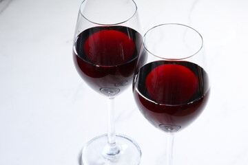 赤ワインが注がれたふたつのワイングラスで、乾杯をしているイメージ
