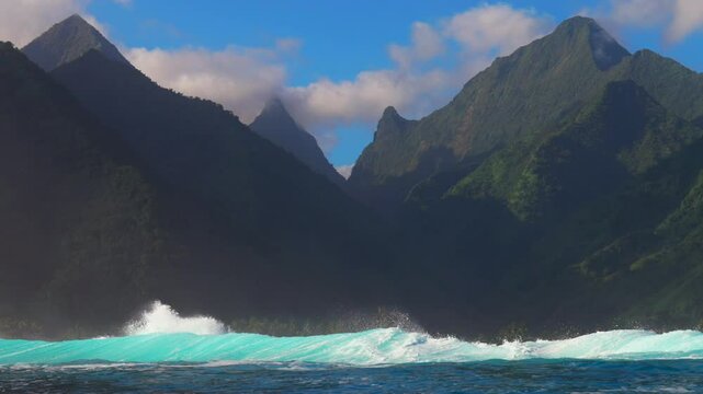 Surfing surf barrel waves Teahupoo Tahiti French Polynesia crashing swell on shallow coral reef South Pacific island towering mountain peaks ocean waterhousing landscape blue sky super slow motion