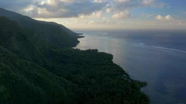 Teahupoo Tahiti bay shoreline sunrise yellow clouds golden hour sunset aerial drone view from mountain peaks to coral reef French Polynesia WSL Surfing summer Olympic venue town village forward pan