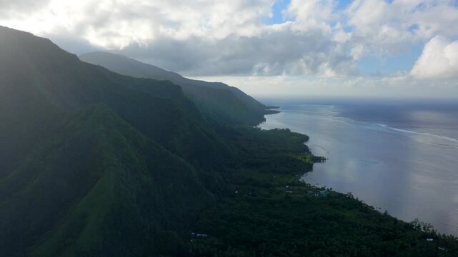 Morning sunrise clouds volcano island mountains Teahupoo Tahiti aerial drone French Polynesia South Pacific surf wave reef channel WSL surfing Olympic venue up the coastline coral reef circle right