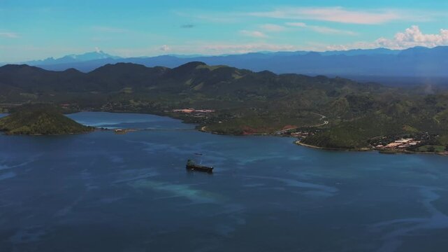 Ela Beach Port Moresby Papa Papua New Guinea Aerial drone oil rig boat blue sky sunny morning bay coastline hills PNG Capital City Central Business District wharf Harbor Idlers Bay circle right