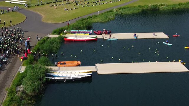 Drone shot of Triathlon at Dorney lake, triathletes are beginning the race and swimming towards the transition area