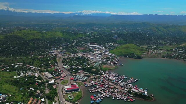 Walter Bay speed boat Port Moresby Papua New Guinea parallax aerial drone capital city Harbour Marina PNG beautiful sunny blue sky morning islands Ela Beach Crown Hotel Plaza Hilton Coral Sea backward