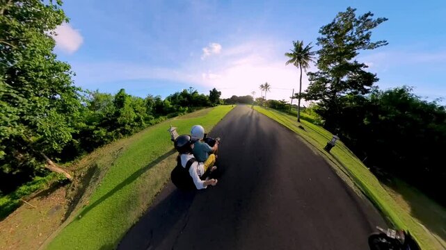 Couple riding on a beautiful sunny road surrounded by lush greenery in a dynamic perspective view. Travel motorcyclist enjoying a peaceful ride on an open road, conveying a feeling of freedom
