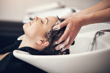 Hands, massage and hairdresser with client in spa, relax and basin for wash and treatment. Soap, salon and hairstyle or cleaning for happy customer person, keratin or scalp shampoo for hair care