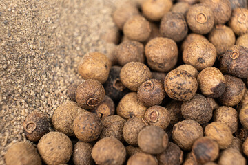 Ground black pepper and peppercorns close-up.