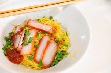 Chinese yellow egg noodles topping slice barbecue pork and boiled cabbage dressing sweet red gravy sauce on bowl