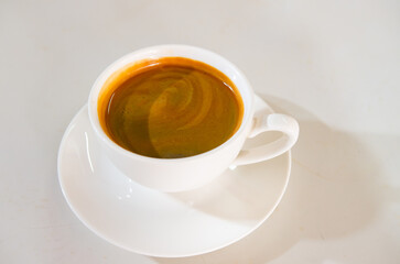 Coffee. Fresh Espresso with Crema Foam on White Table Background.