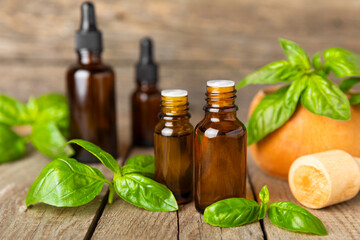 Basil essential oil on a textured wooden background. Basil essential oil and fresh leaves. Aromatherapy. Aroma oil. Medical herbs. Alternative medicine. Place for text. Copy space.