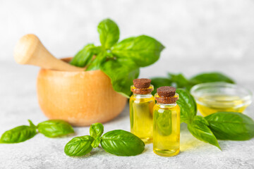 Basil essential oil on a textured wooden background. Basil essential oil and fresh leaves. Aromatherapy. Aroma oil. Medical herbs. Alternative medicine. Place for text. Copy space.