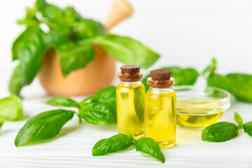 Basil essential oil on a textured wooden background. Basil essential oil and fresh leaves. Aromatherapy. Aroma oil. Medical herbs. Alternative medicine. Place for text. Copy space.