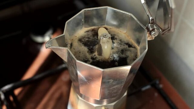 Black coffee pouring out of a geyser coffee maker