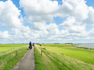 Friesland, Netherlands, August 8th 2023: Cycling on a small trail along a dyke