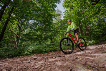 Cyclist teen enjoying ride through a scenic, lush green forest