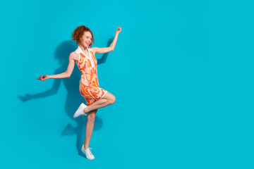 Obraz premium Full size photo of pretty young girl dancing enjoy discotheque wear trendy orange outfit isolated on aquamarine color background