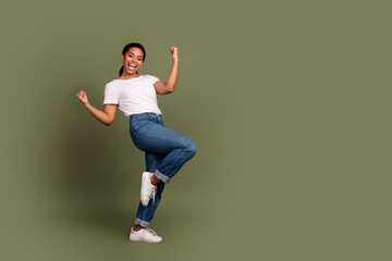 Full body portrait of pretty young woman raise fists empty space wear white t-shirt isolated on...