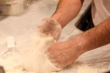 Fototapeta premium person kneading dough