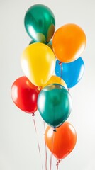 Colorful balloons are floating tied together with red ribbons against a white background. This image evokes joy, celebration, and festive occasions