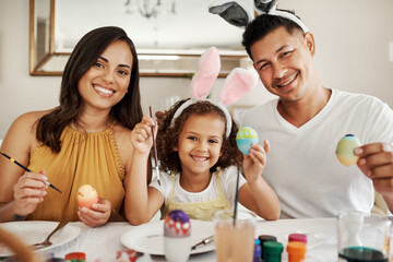 Family, portrait and painting egg for easter, holiday and learning together in home with bunny ear. Mother, girl and dad in house for teaching, celebration and vacation at creative art with color