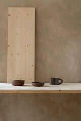 An elegant minimalist concept featuring modern ceramic mugs and cups on a neutral beige wooden table background. Minimalist design.