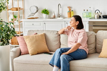 Obraz premium A mature woman relaxes on a couch in her cozy living room.