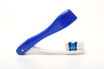 Blue folding toothbrush for traveling on a white background