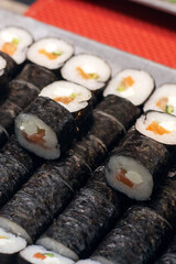 A tray with sushi rolls displayed on a vibrant red table