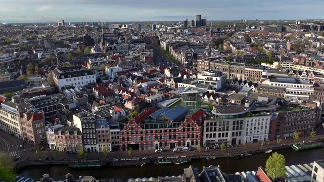 Historical Center of Amsterdam, Netherlands. Aerial Drone Shot of Traditional Dutch houses on narrow street and channel.