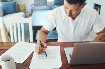 Remote work, laptop and man with documents at table for review, sentence structure or editing. Proofreading, freelance and person for check grammar, verify references or format guidelines in home