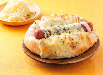 Cheese sausage buns served on wooden board isolated on orange background side view of hong kong cafe baked food dessert