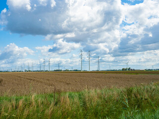 Groningen, Netherlands - August 9th 2023: Huge high-voltage transmission line over farmland
