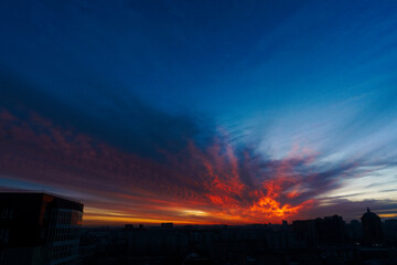 evening sky over the city, scarlet clouds in the setting sun, red sunset over the city