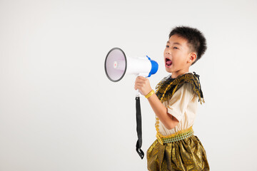 Portrait Thailand kid boy smiling traditional Thai dress costume shouting by megaphone, studio shot...