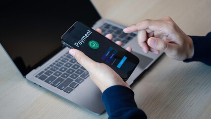 Buy now pay later online shopping concept. Hands holding mobile phone on blurred store as...