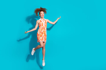 Full length photo of lovely young lady jump excited look empty space dressed stylish orange garment...