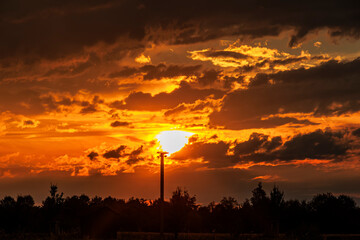 Bright red sunset over Augsburg between dark storm clouds