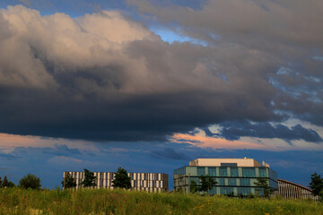 Modern office building in the Innovation Park in Augsburg under dark storm clouds in the evening