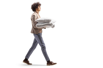 Naklejka premium Young man walking and holding a pillow and duvet