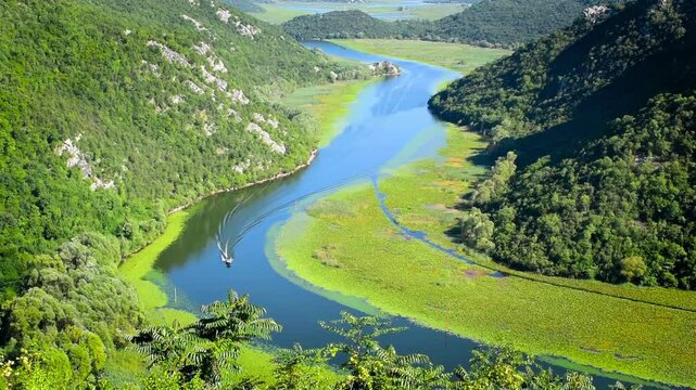 Speed boat on Rijeka Crnojevica River. Famous view of Skadar Lake at Pavlova Strana viewpoint. Scenic nature in Montenegro. Travel the Balkan region.
