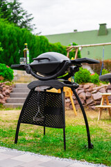 Black Electrical Home Grill in a Green Backyard Garden Ready to Heat Up Grill Meat and Vegetables...