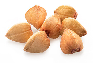 Several hulled kernels of buckwheat cereal isolated on white background.