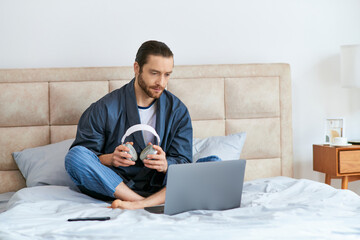 A man gazes at a laptop screen while seated on a bed in a peaceful morning setting.