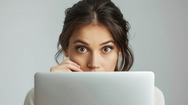 young professional business blonde woman with surprised shock facial expression while looking at on front laptop computer screen display and office background