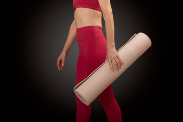 close up of a sporty woman holding an exercise mat, studio series