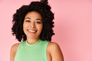 Smiling woman in green top looks directly at camera.