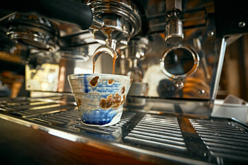 Close up of coffee machine pouring espresso in cafe