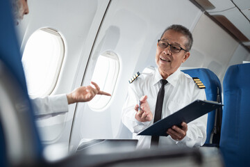 Portrait of serious airplane captain in uniform preparing flight in aero simulator cockpit.