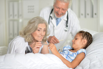 Little girl in the hospital with her grandmother and doctor