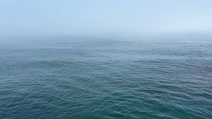Blue sea waves and sky at misty morning.