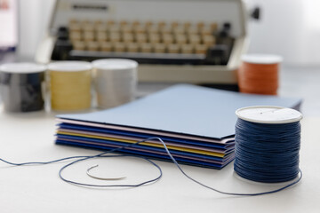 High-quality image of a person binding a book using traditional coptic stitch technique. DIY...